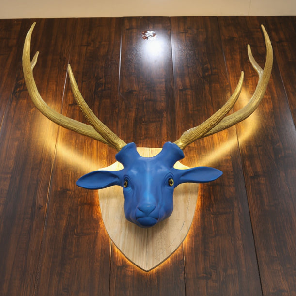 Blue deer head mount with gold antlers on a wooden floor 