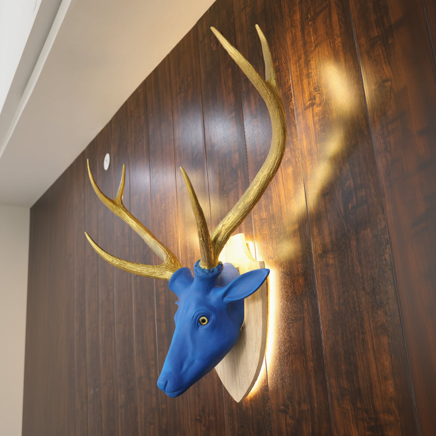 Blue deer head with gold antlers on a wooden floor
