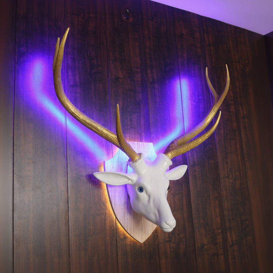 Decorative animal head with large antlers on a wooden wall
