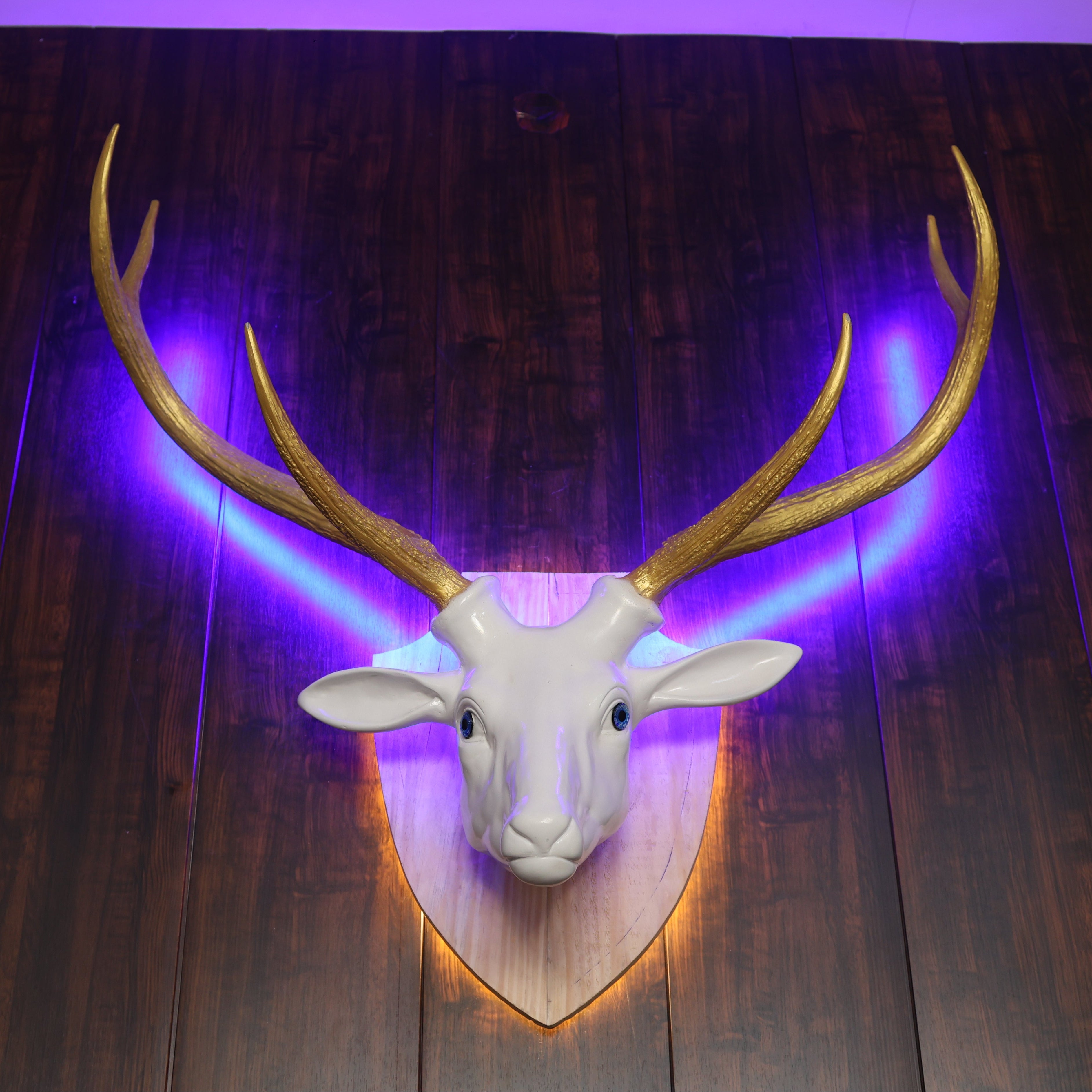 Deer head mount with glowing antlers on a wooden wall