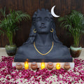 Statue with candles and flowers on a wooden floor