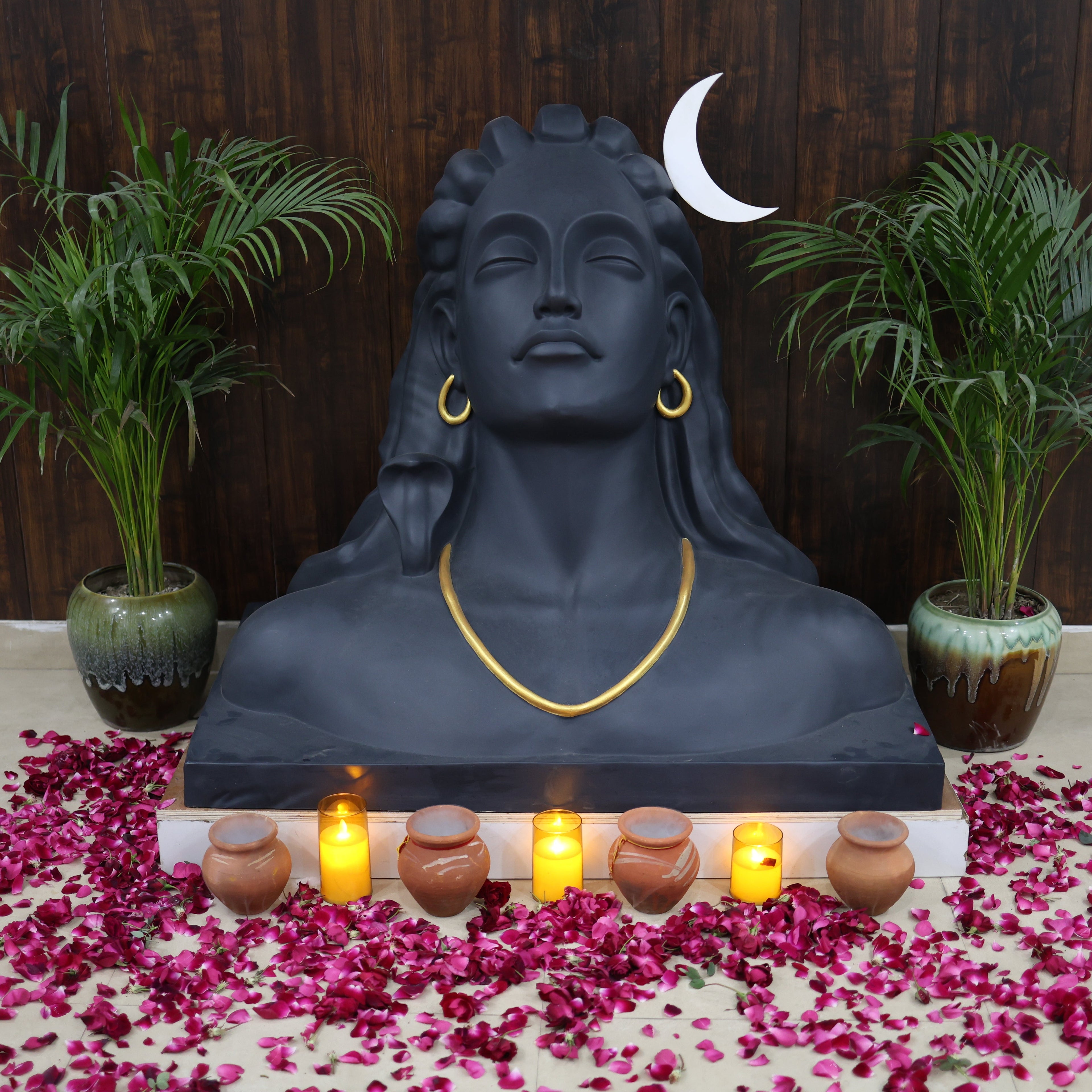 Statue with candles and flowers on a wooden floor