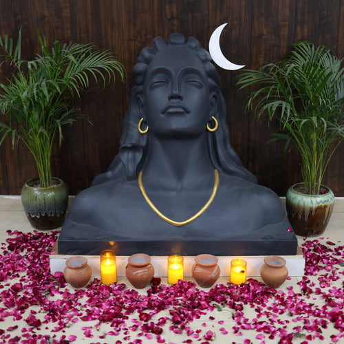 Statue with candles and flowers on a wooden floor